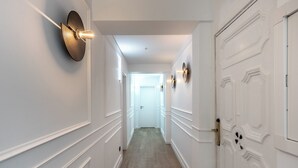 A hallway with white walls, a wooden floor, and a white door at the end. -  Arenal Rooms Bilbao (Bilbao)
