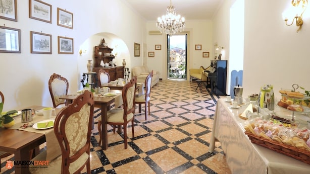 Un comedor con suelo a cuadros, muebles de madera y cuadros en las paredes.