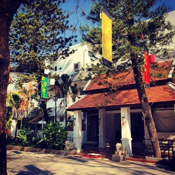 A building with a red tiled roof, white columns, and a statue in front. - The Odyssey Serviced Apartment (Chiang Mai)
