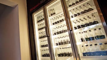 Een gekoelde vitrine met meerdere planken vol met flessen drank.