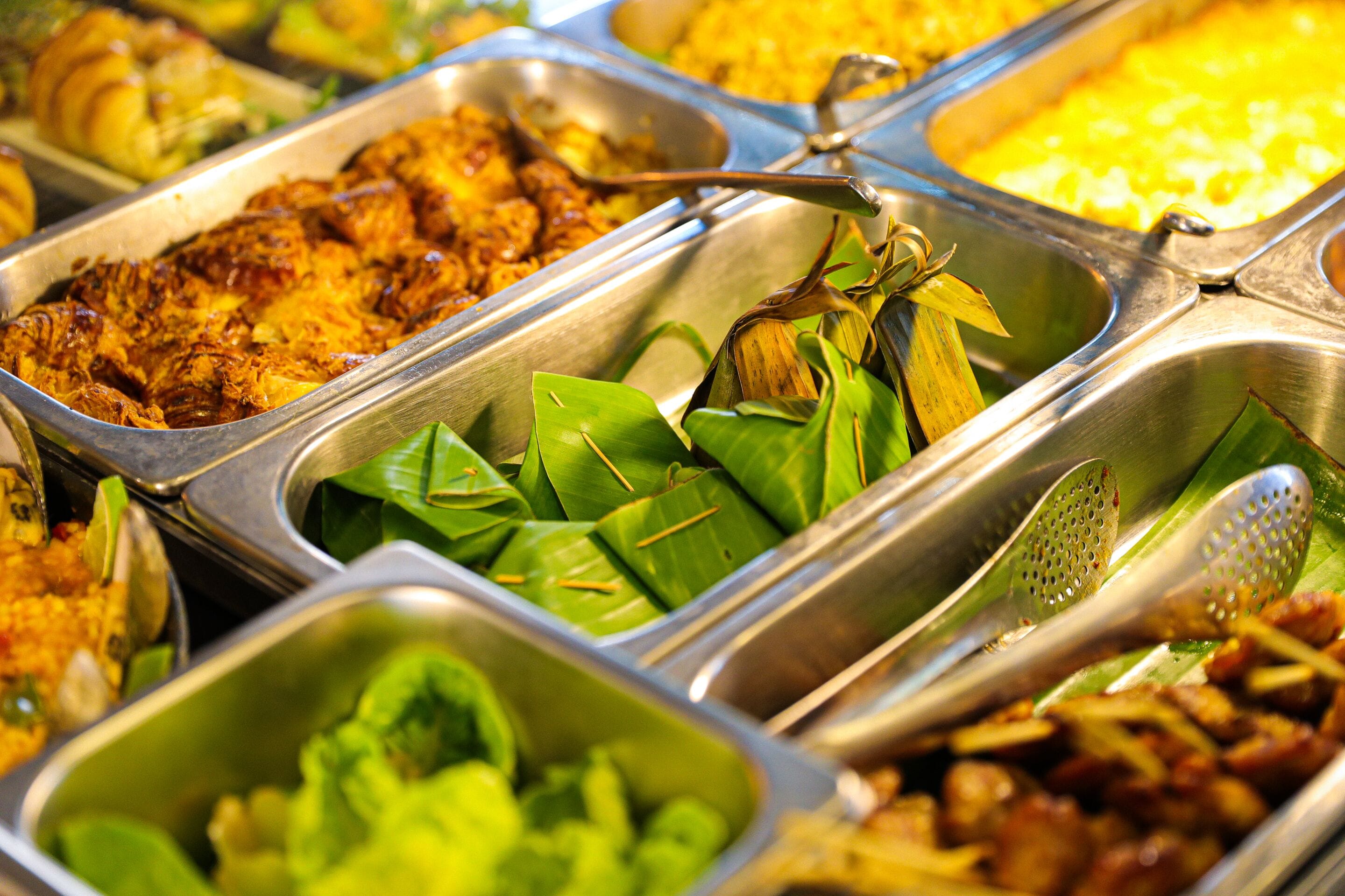 Un bufé con diversos platos, incluyendo arroz, verduras y carne.