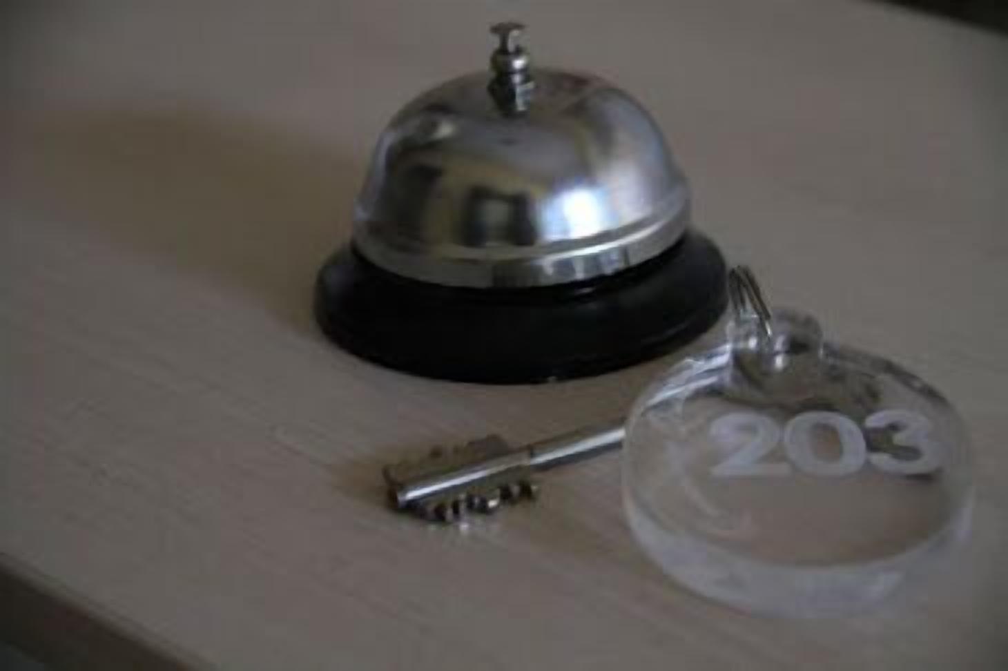 A key and a glass bell with the number 203 on it.
