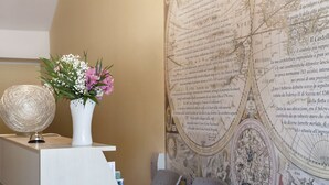 A reception desk with a globe, a vase of flowers, and a large map on the wall. - Quarantadue Quindici (Termoli)