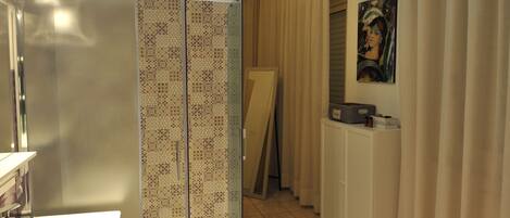 Un baño moderno con cabina de ducha de vidrio, un lavabo y un mueble.