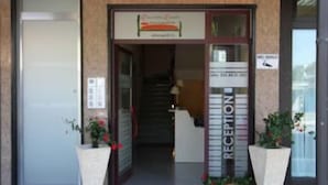 A reception area with a sign indicating 'Reception' and a staircase leading to an upper floor. - Quarantadue Quindici (Termoli)