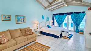 A bedroom with a bed, a sofa, and a nightstand. - The Lighthouse Villas (Cane Garden Bay)
