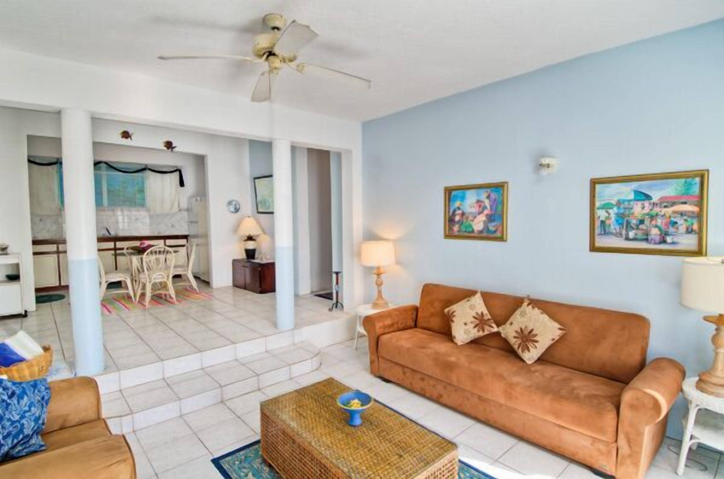 A living room with a sofa, a coffee table, and a dining area with a table and chairs.