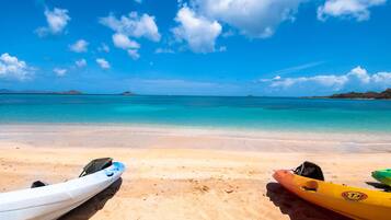 A beach with kayaks and a clear blue sky.