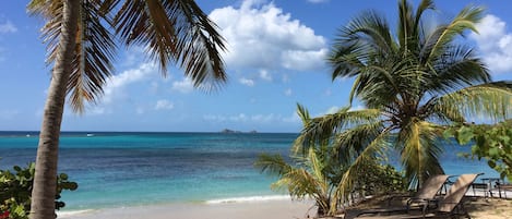 On the beach, white sand, sun loungers, beach umbrellas