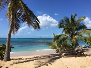 På stranden, hvit sand, solsenger og parasoller