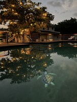 Una piscina al aire libre, tumbonas