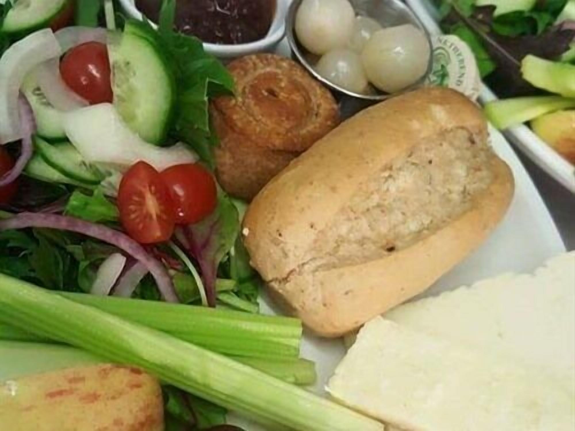 A plate with a salad, bread, and cheese.