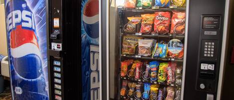A vending machine with Pepsi and a snack vending machine with various chips and snacks.