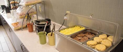 Buffet amb diversos aliments, com ara ous, botifarra i galetes.