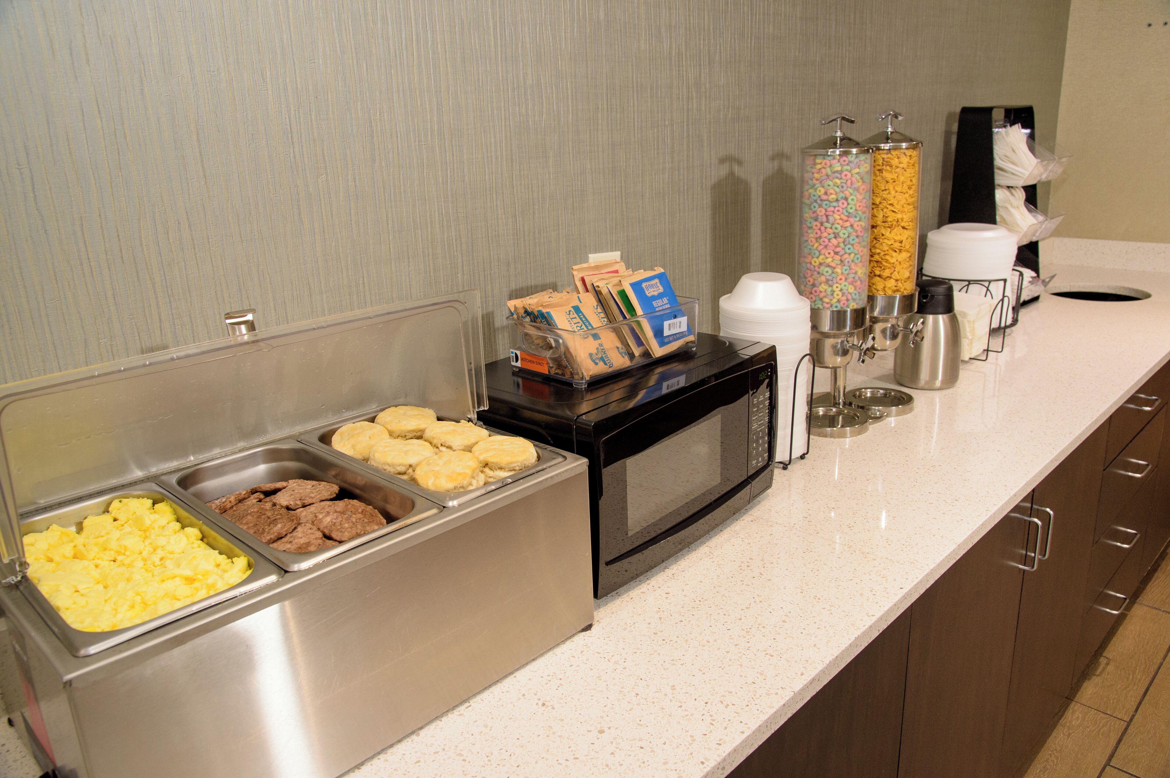 A buffet area with various food options and a coffee station.