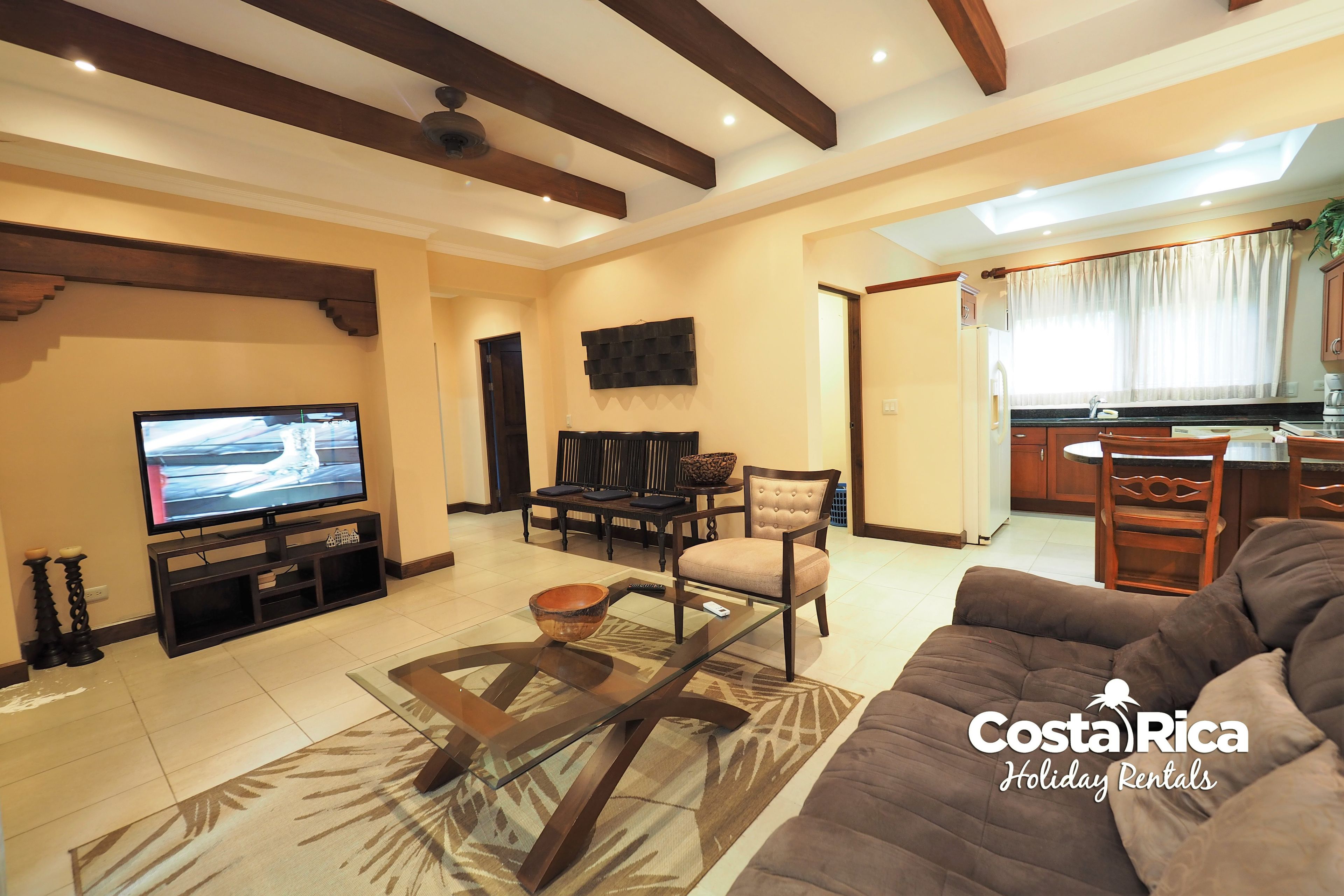 A living room with a TV, sofa, and dining area.