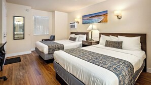 A hotel room with two beds, a desk, and a chair. There is a painting on the wall and a window with blinds. - Sunbeam Motel (San Luis Obispo)