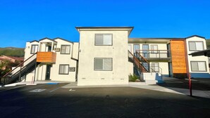 A modern building with a central tower, multiple balconies, and a parking area. - Sunbeam Motel (San Luis Obispo)