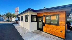 A motel with a modern design, featuring a wooden facade and a black door. - Sunbeam Motel (San Luis Obispo)