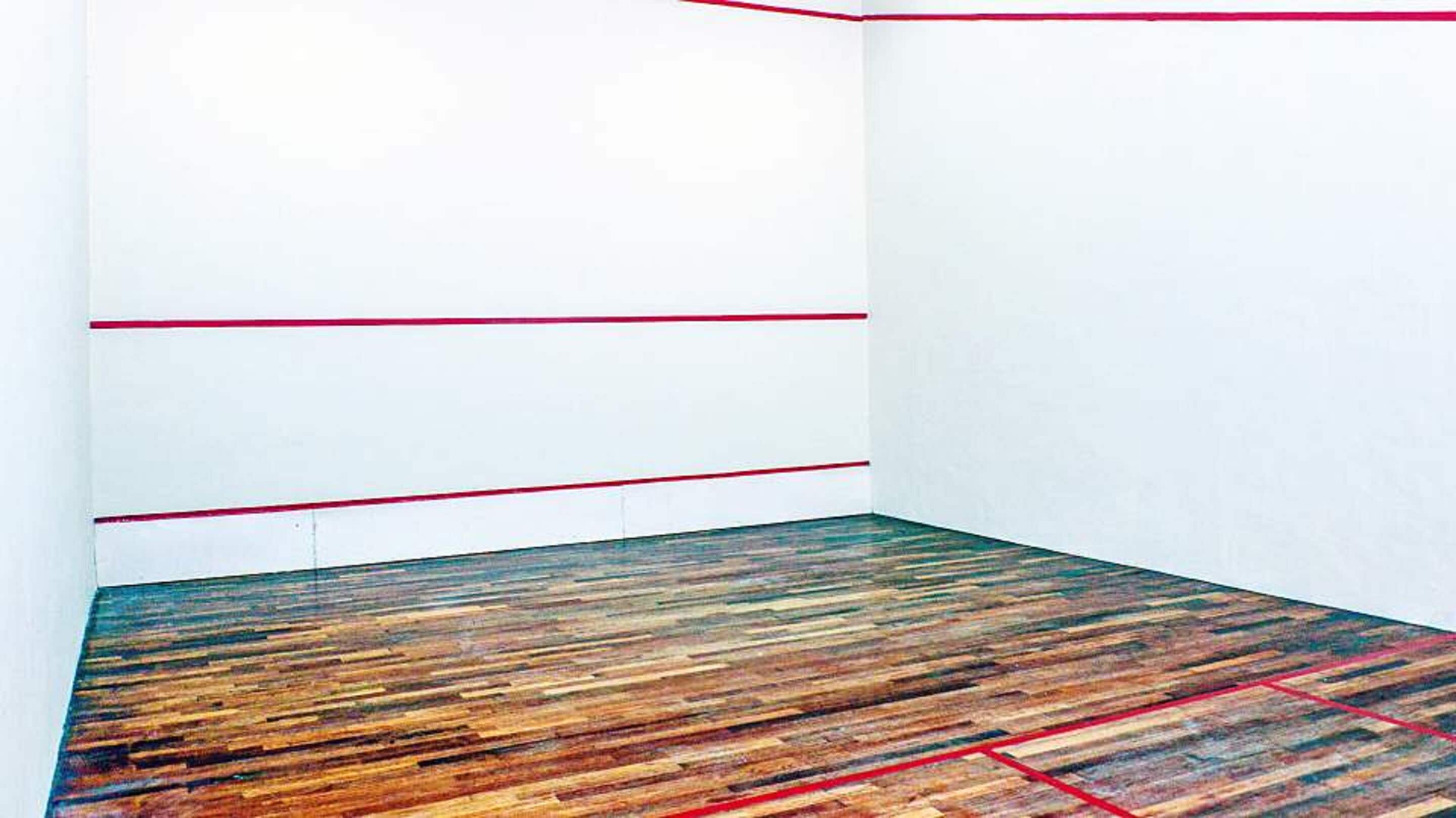 Una habitación con suelo de madera y líneas rojas que marcan las paredes.