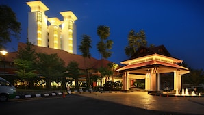Un hotel con una torre destacada y un área de entrada techada.