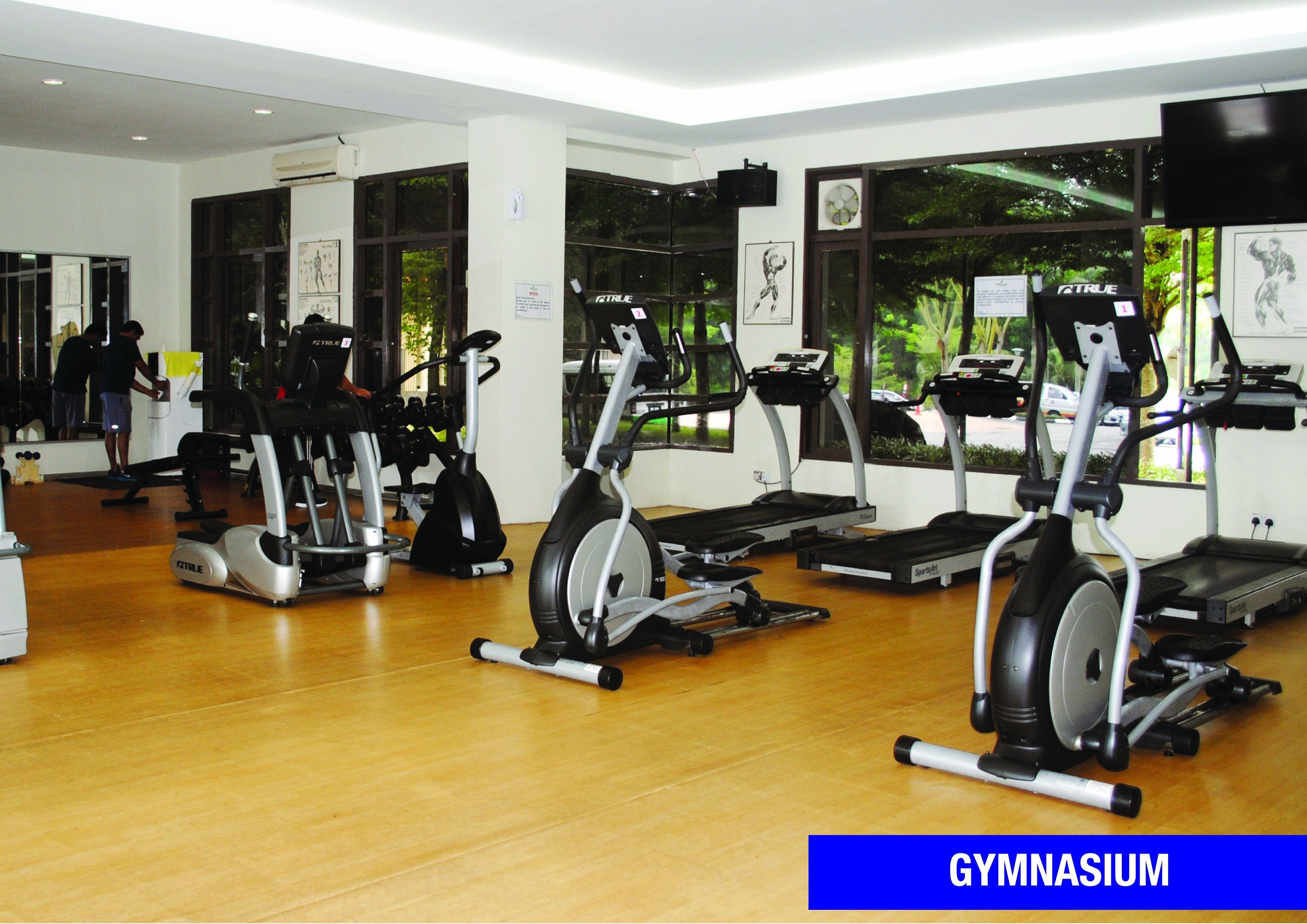 Ein Fitnessraum mit Ergometer, Laufbändern und Holzboden.