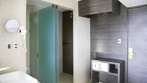 Un baño moderno con bañera, cabina de ducha verde, tocador con espejo y retrete.