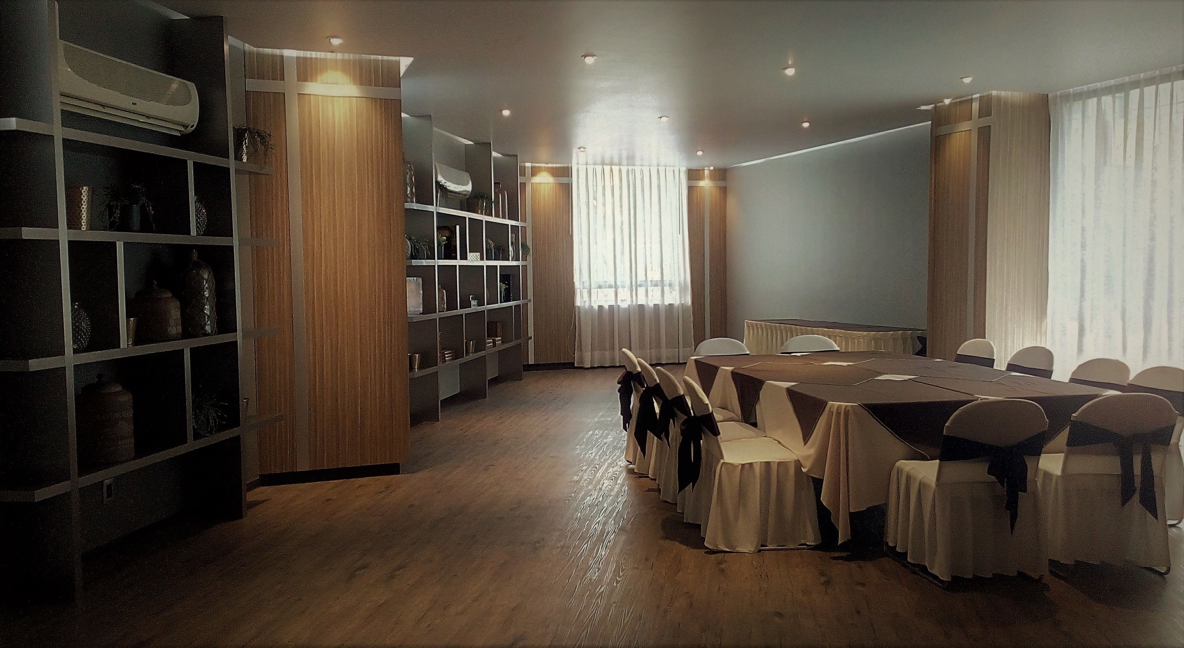 A conference room with a long table, chairs, and a bookshelf.
