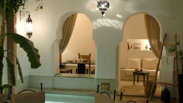 A pool area with lounge chairs, a dining area, and a sofa. - Riad Tawargit (Marrakech)