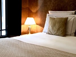 Una camera d'albergo con un letto, una lampada e una finestra.