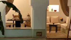 A cozy living area with a sofa, a small table, and a decorative vase. - Riad Tawargit (Marrakech)