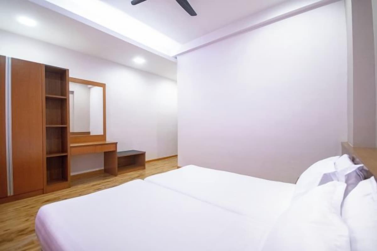 A bedroom with a bed, a wooden wardrobe, and a small bench.