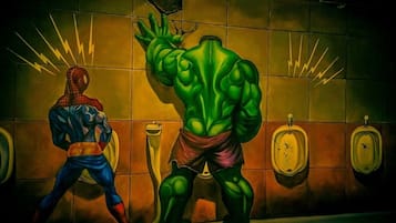Unique mural adorns the restroom, featuring a dynamic superhero character.