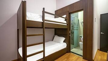 A bunk bed room with a wooden frame, white bedding, and a wooden floor.