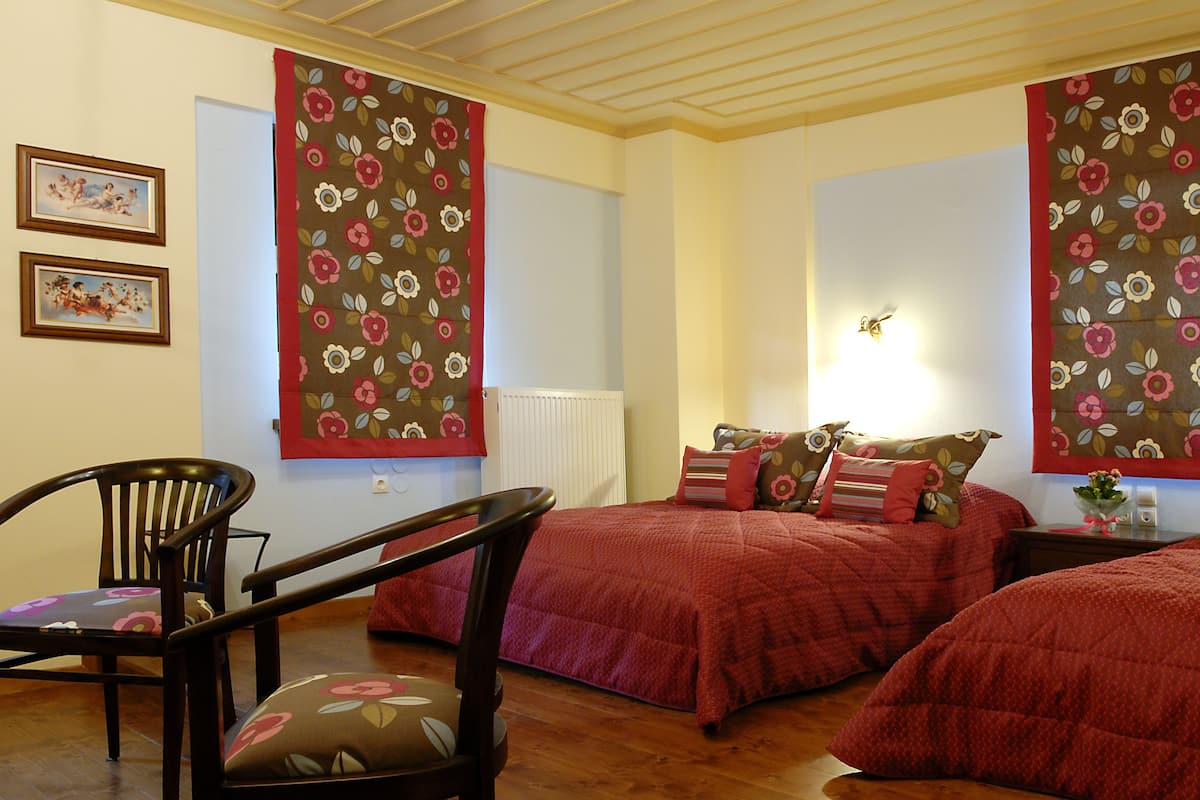 Quarto com duas camas, uma cadeira e um radiador.