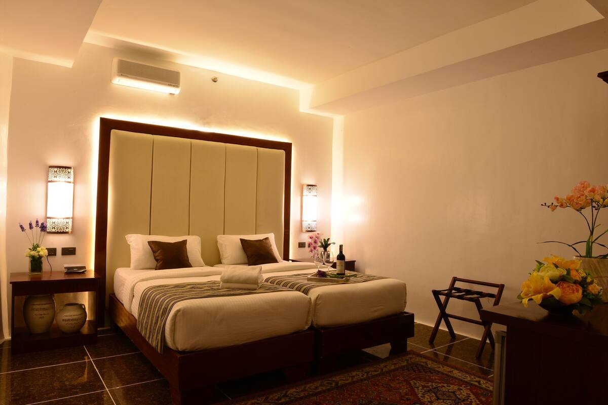 A hotel room with a large bed, bedside tables, a desk, and a chair.