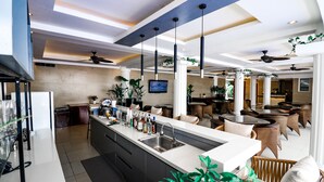 A modern kitchen with a central island, bar area, and dining space with wicker furniture.