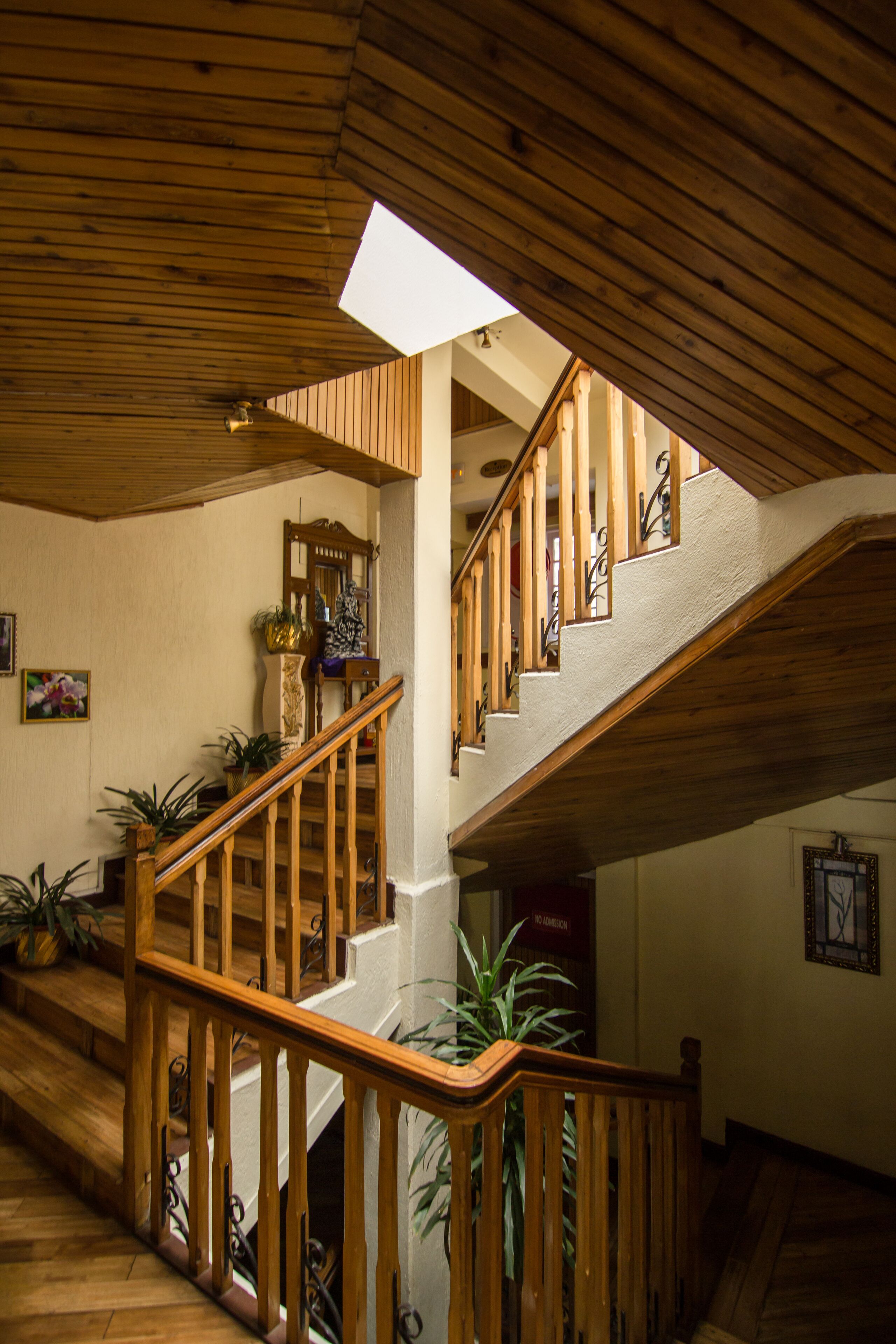 A wooden staircase with a skylight, leading to an upper floor.