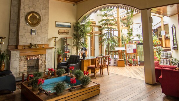 A spacious lobby with a wooden floor, a fireplace, and a large stained glass ceiling. - Central Heritage Resort & Spa, Darjeeling (Darjeeling)