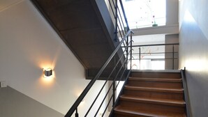 Una escalera moderna con escalones de madera y barandillas de metal que conduce a un piso superior.