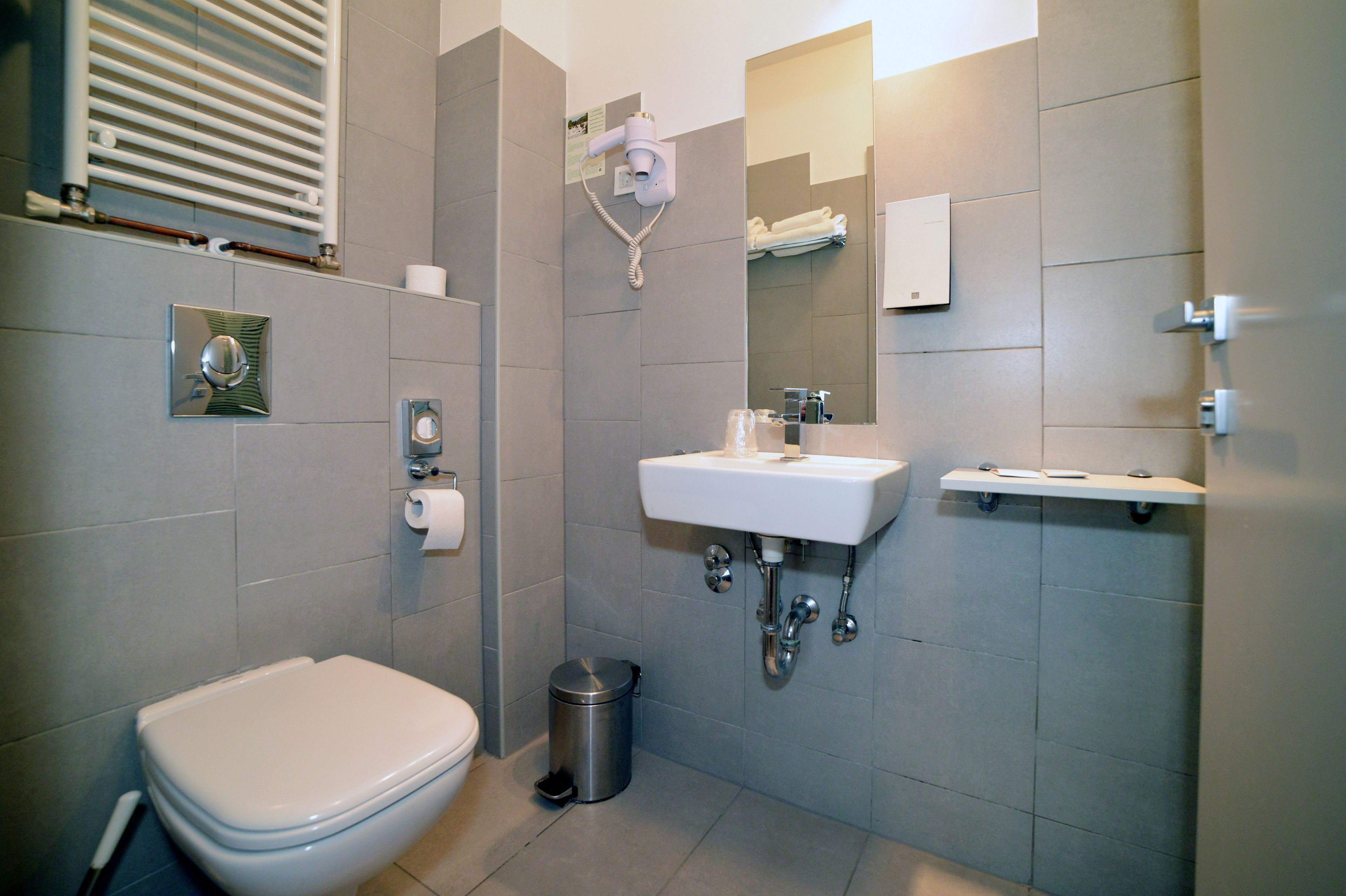 A modern bathroom with a toilet, sink, and shower.