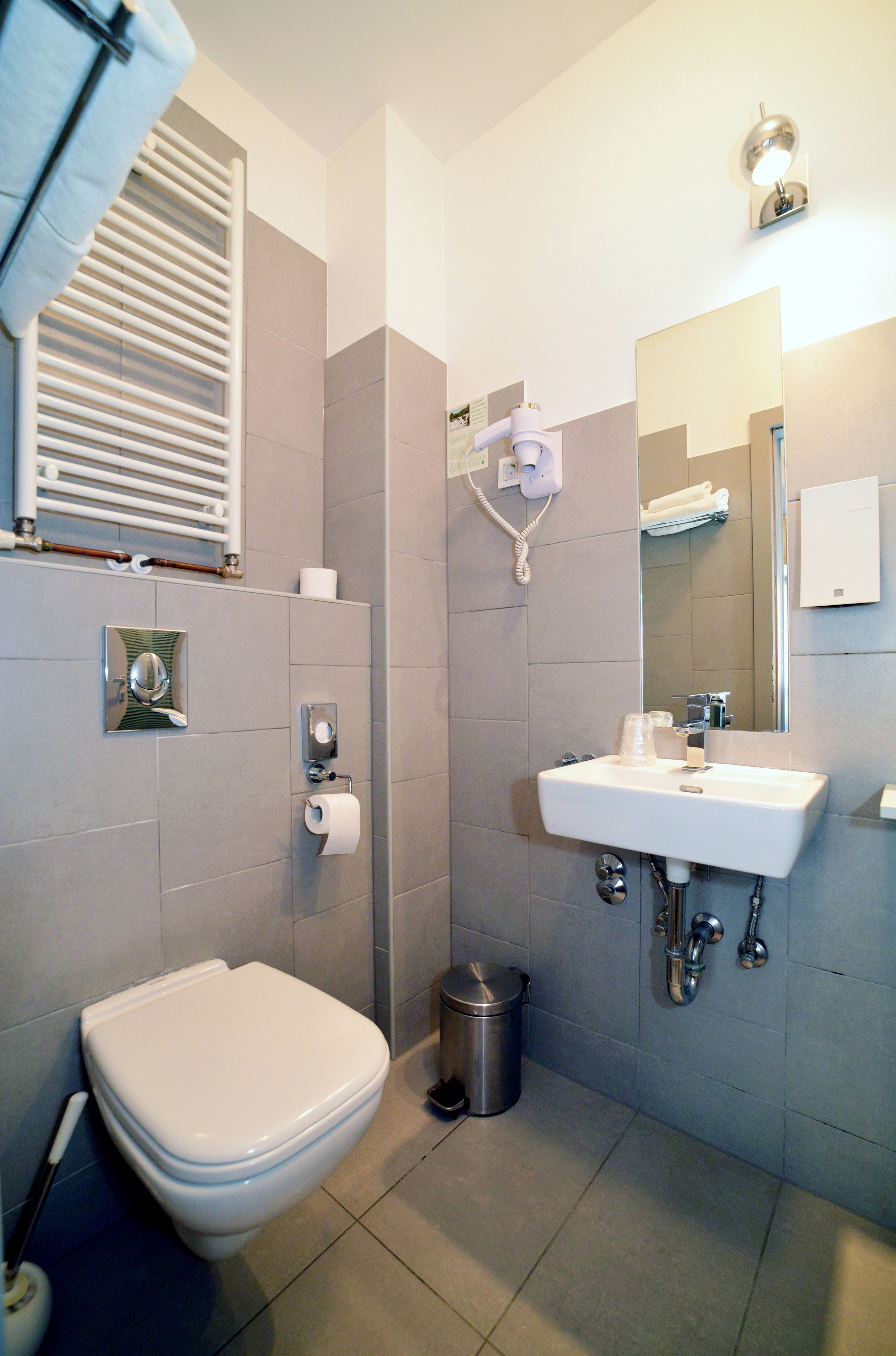 Un baño moderno con inodoro, lavamanos y espejo.