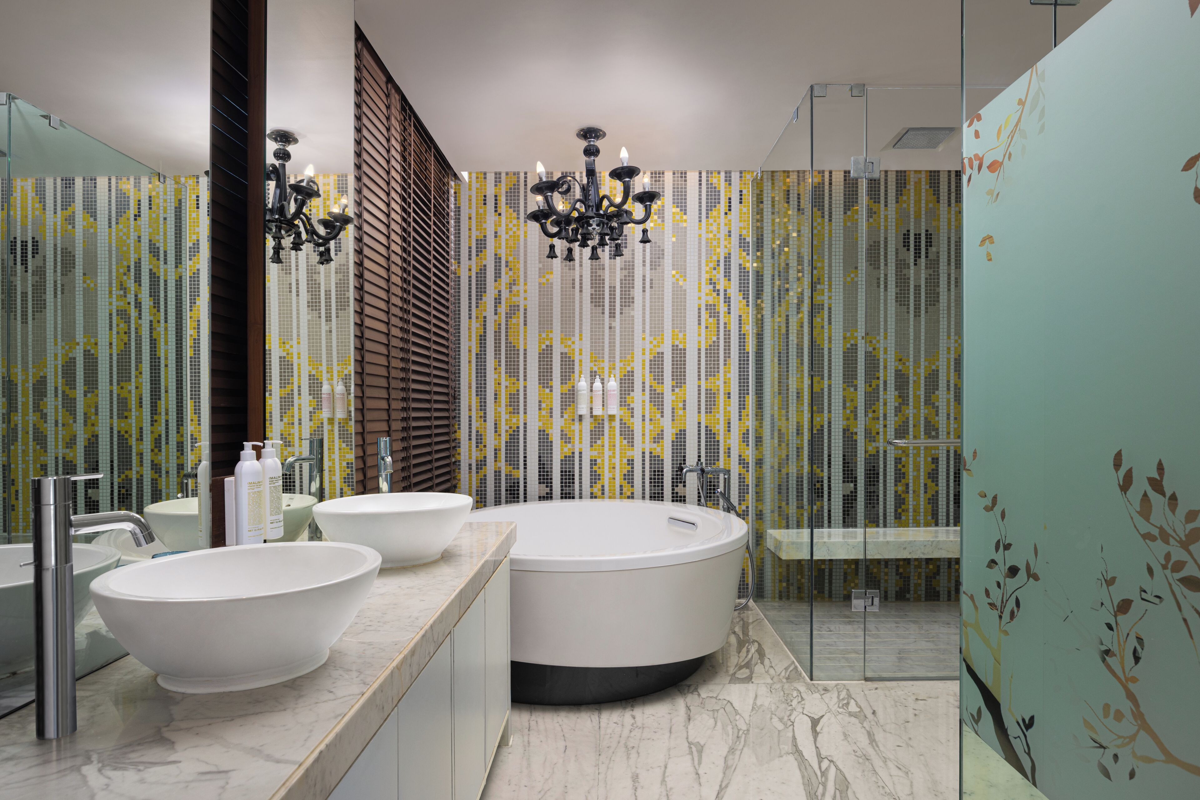 A modern bathroom with a large bathtub, two sinks, and a shower area.