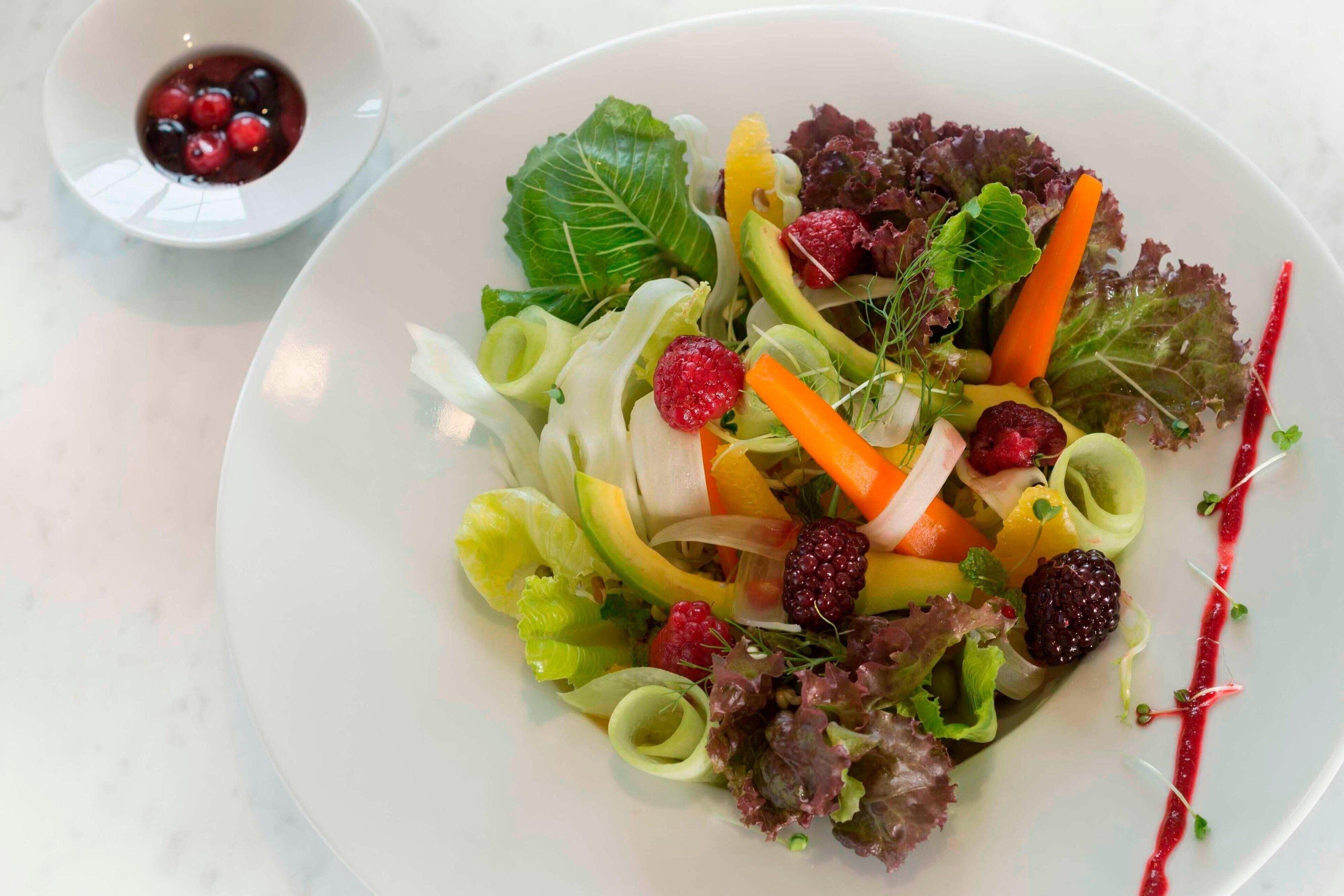 Een bord met gemengde salade en fruit.