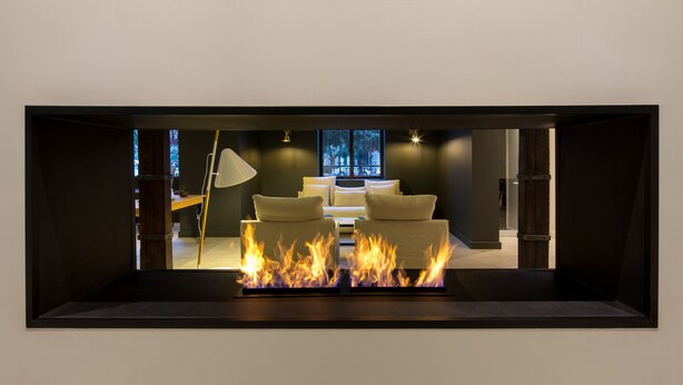 A modern living room with a fireplace, a sofa set, and a lamp. - Altiplanico Bellas Artes (Santiago)