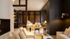 A modern living room with a fireplace, a sofa, a coffee table, and a bookshelf. - Altiplanico Bellas Artes (Santiago)