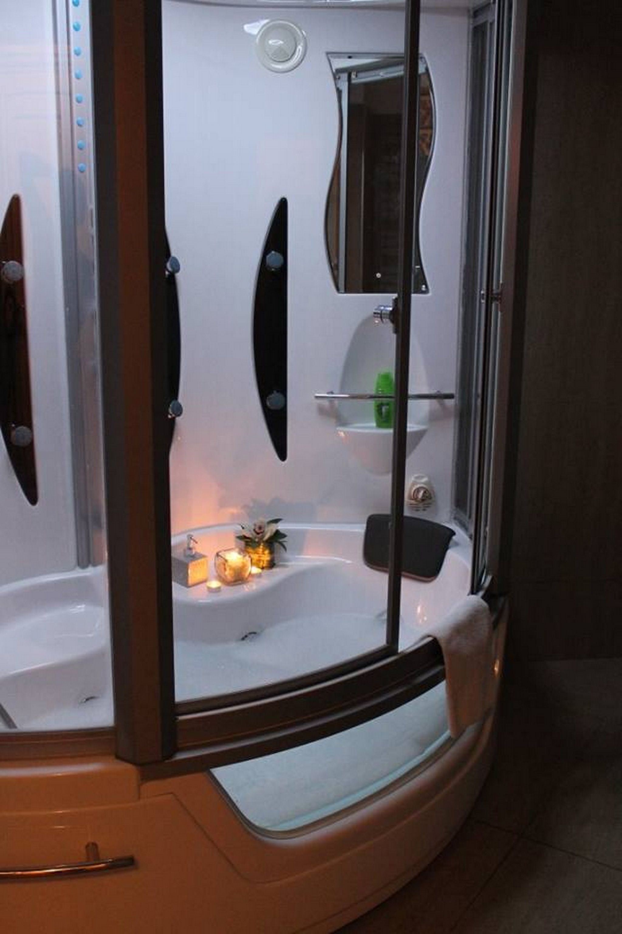 A modern bathroom with a glass-enclosed shower, a bathtub, and a vanity with a mirror.
