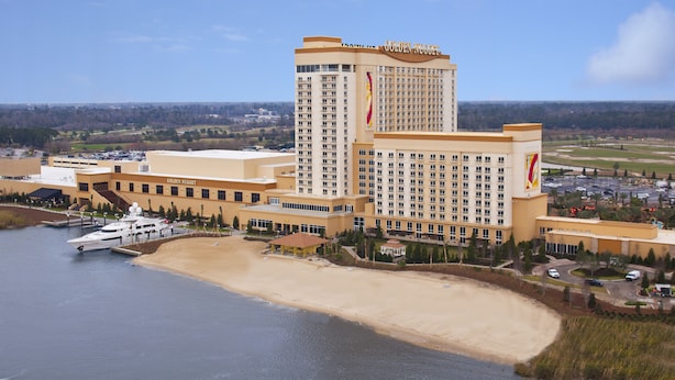 Un hotel grande con una torre destacada y ubicación frente a la playa.