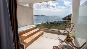 A balcony with a view of the sea, a bathtub, and wicker chairs. - Enjoy Lichnos Bay Village, Camping, Hotel & Apartments (Parga)