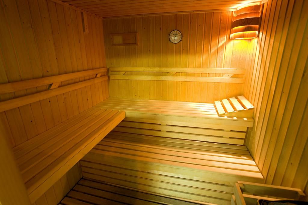 A sauna with wooden benches and a clock on the wall.